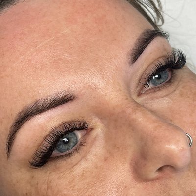 A closeup of a girl with lush eyebrows and lashes