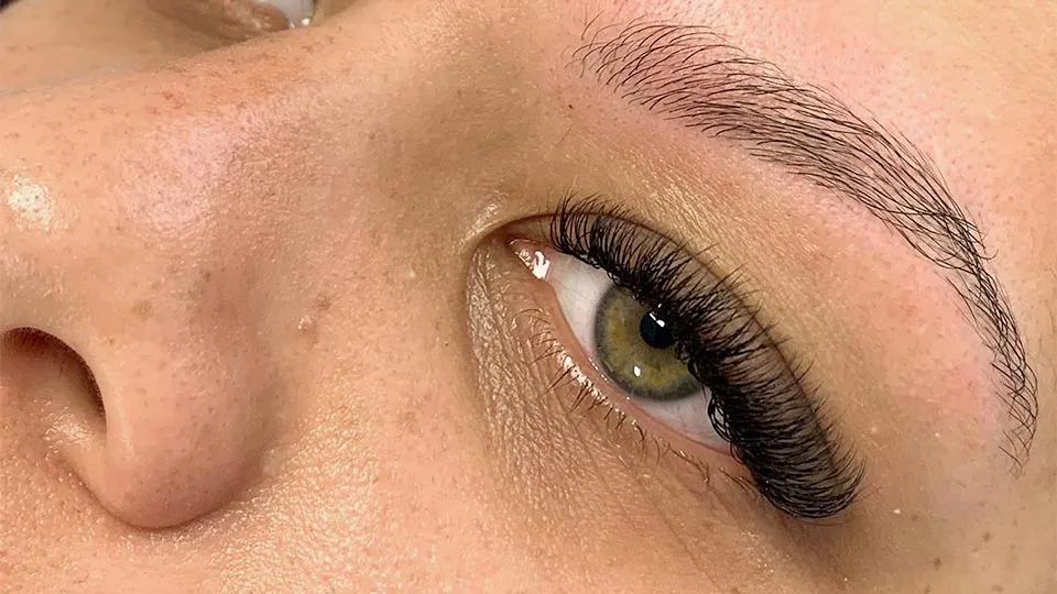 Girl with green eyes after eyebrow and eyelash treatment